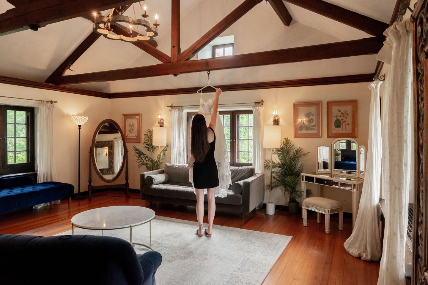 A person hanging a wedding dress in a traditional suite