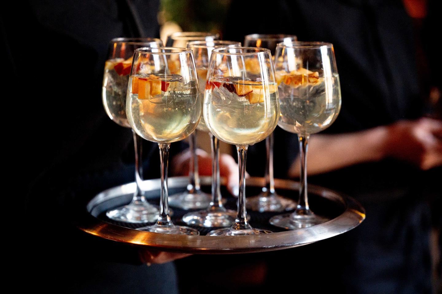 A server with a tray of cocktails