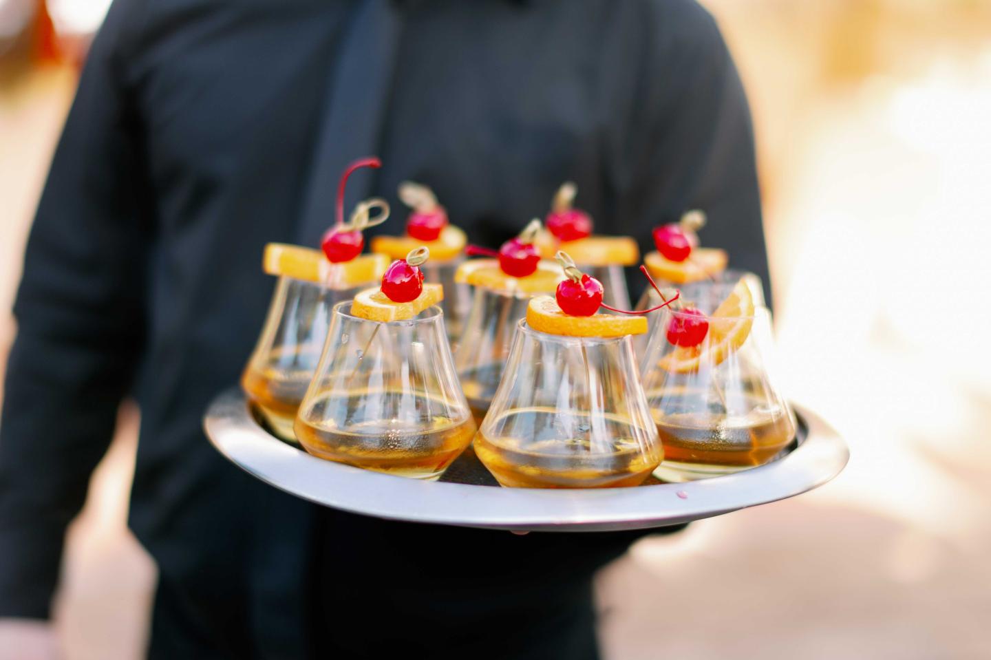 A waiter holding cocktails