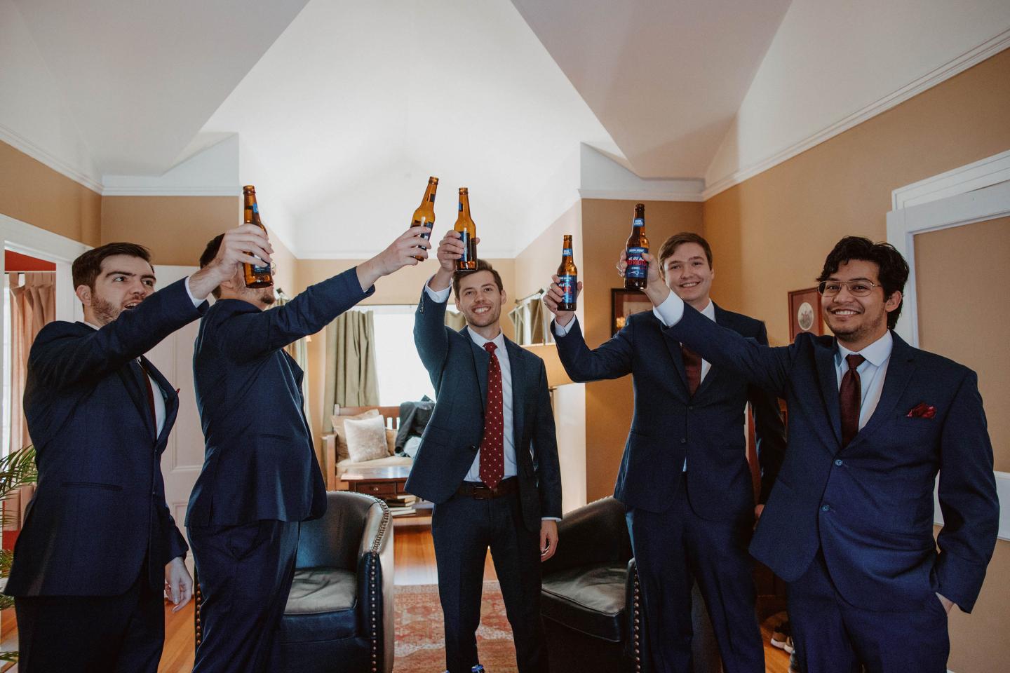 Groomsmen cheersing beers