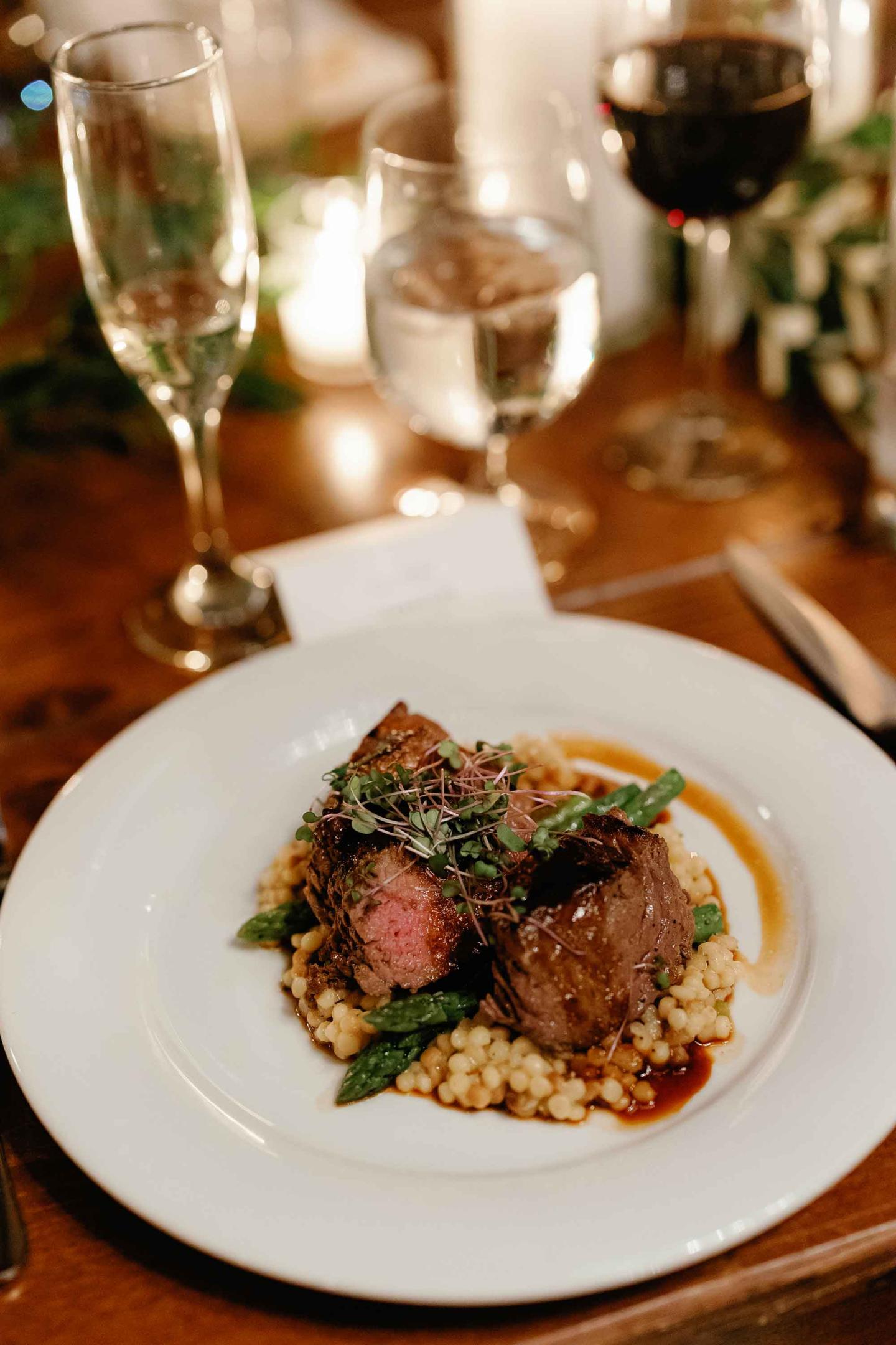 A plate of rare beef with asparagus on a bed of risotto