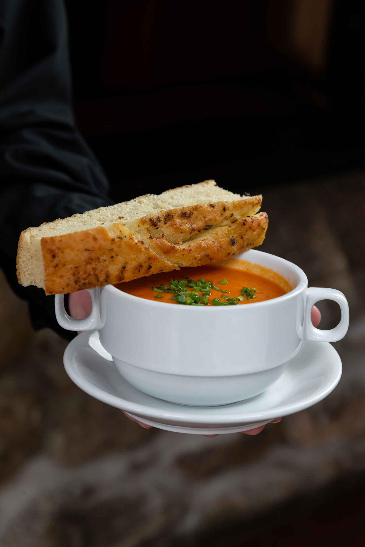 A bowl of tomato soup with focaccia bread