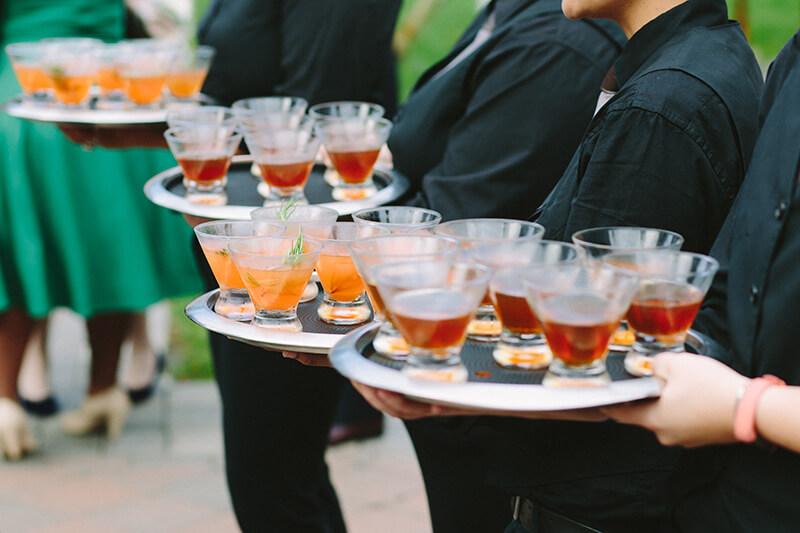 Waiters holding trays of cocktails