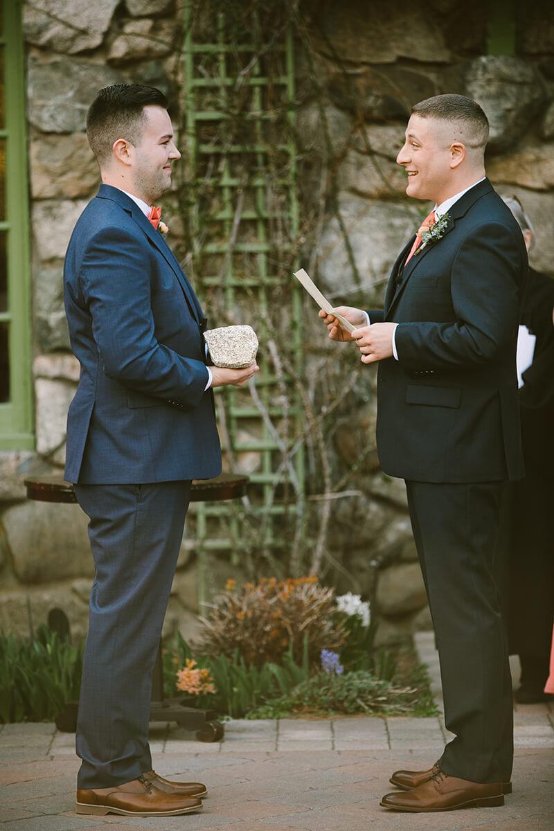 Two grooms reading vows