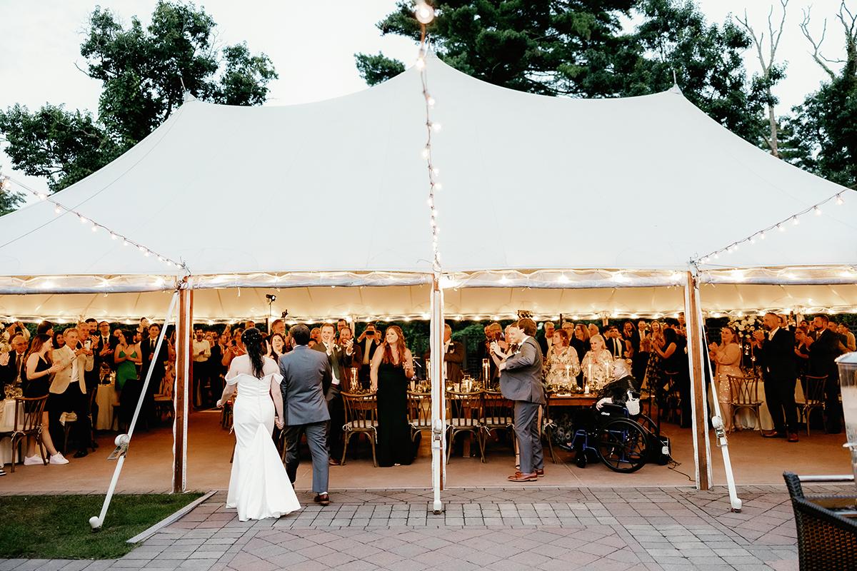 bride and groom entering tent