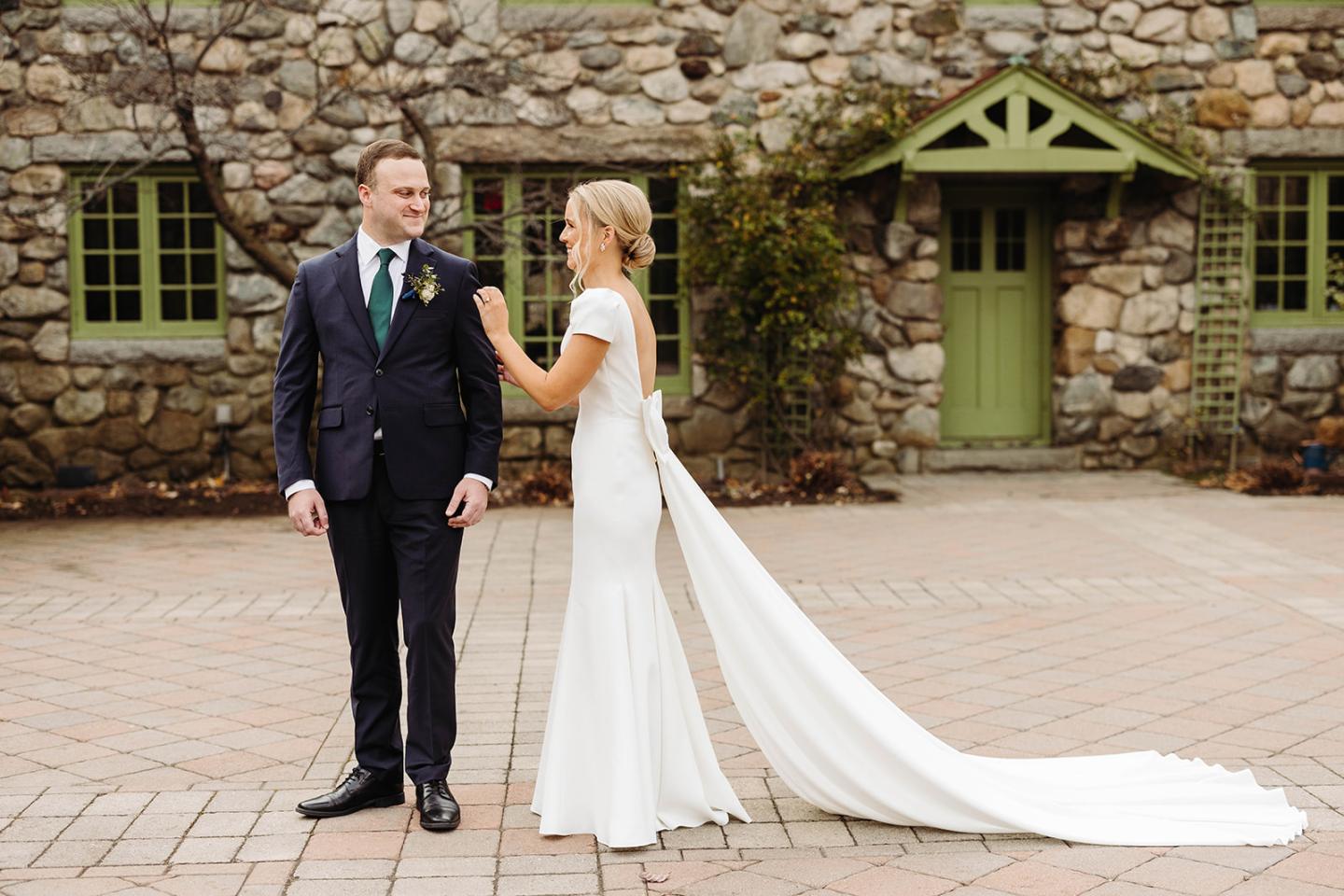 Bride and groom in courtyard of field stone mansion