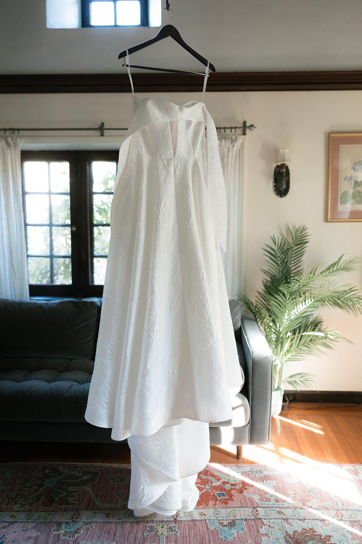 White wedding dress hanging in a wedding suite