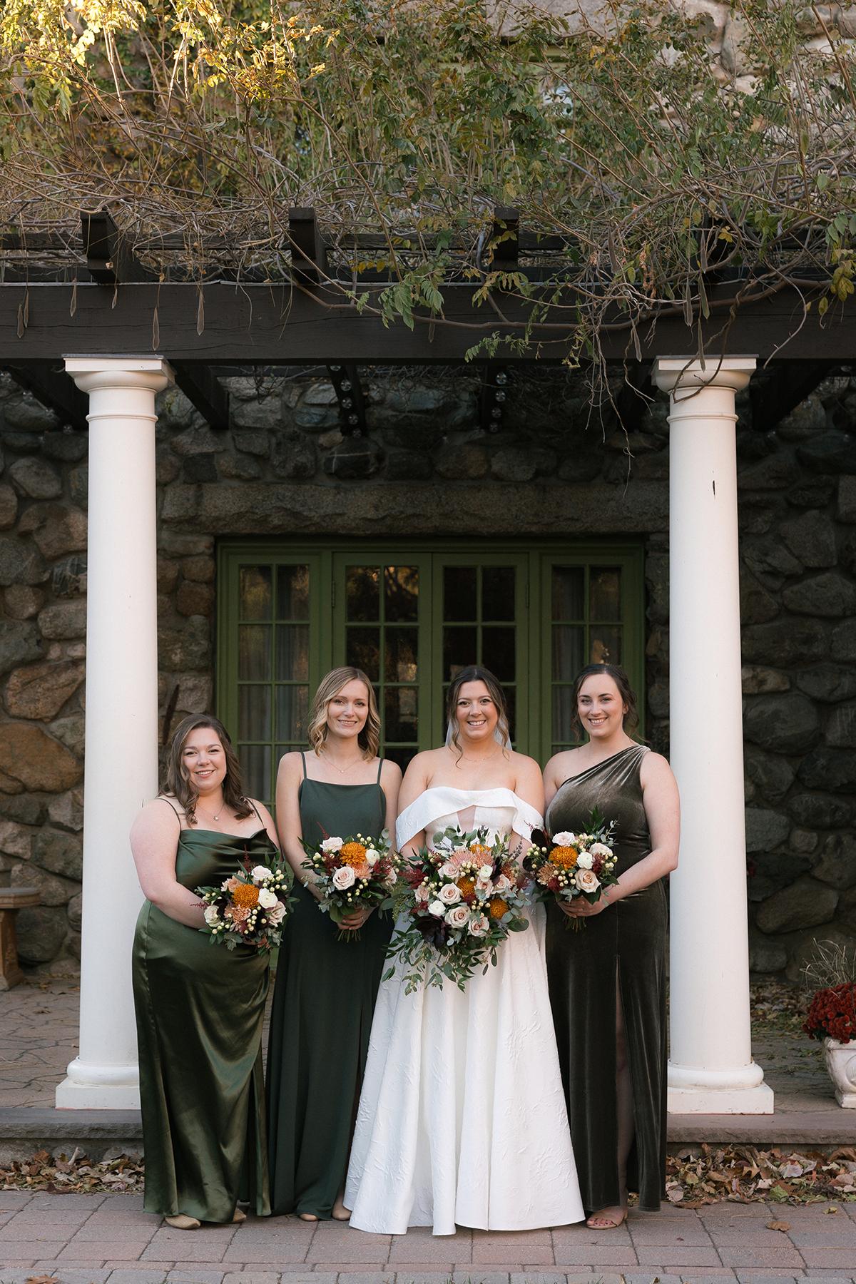 bridesmaids in green gowns by pergola