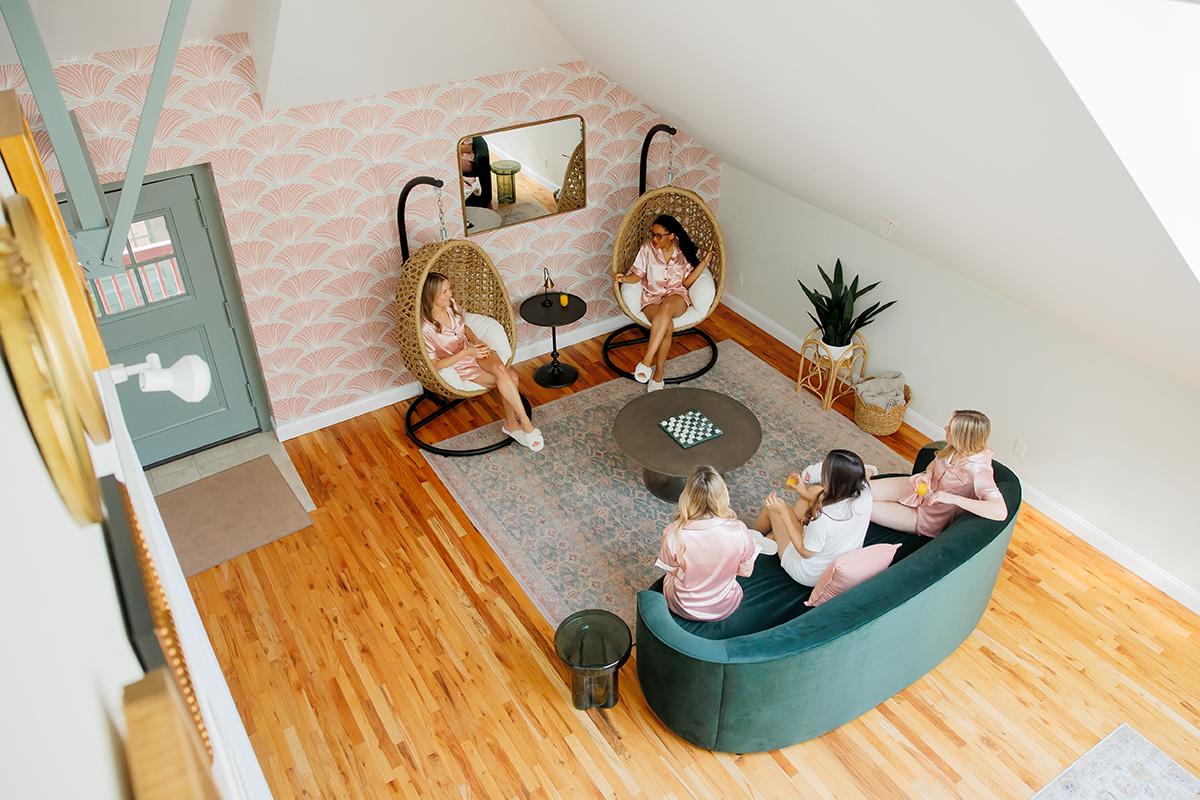 Cozy loft living room with people relaxing on chairs and a sofa.