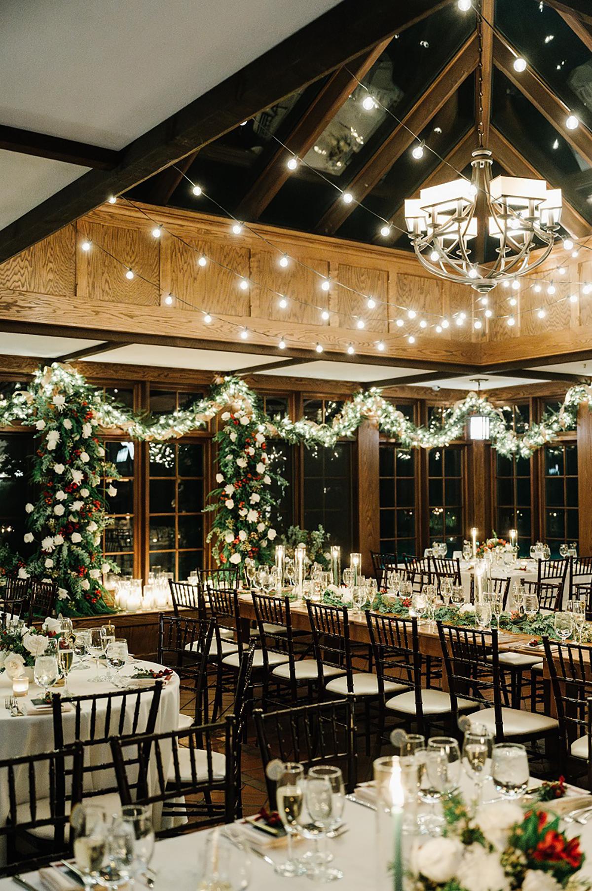 Elegant banquet hall with floral decorations and string lights.