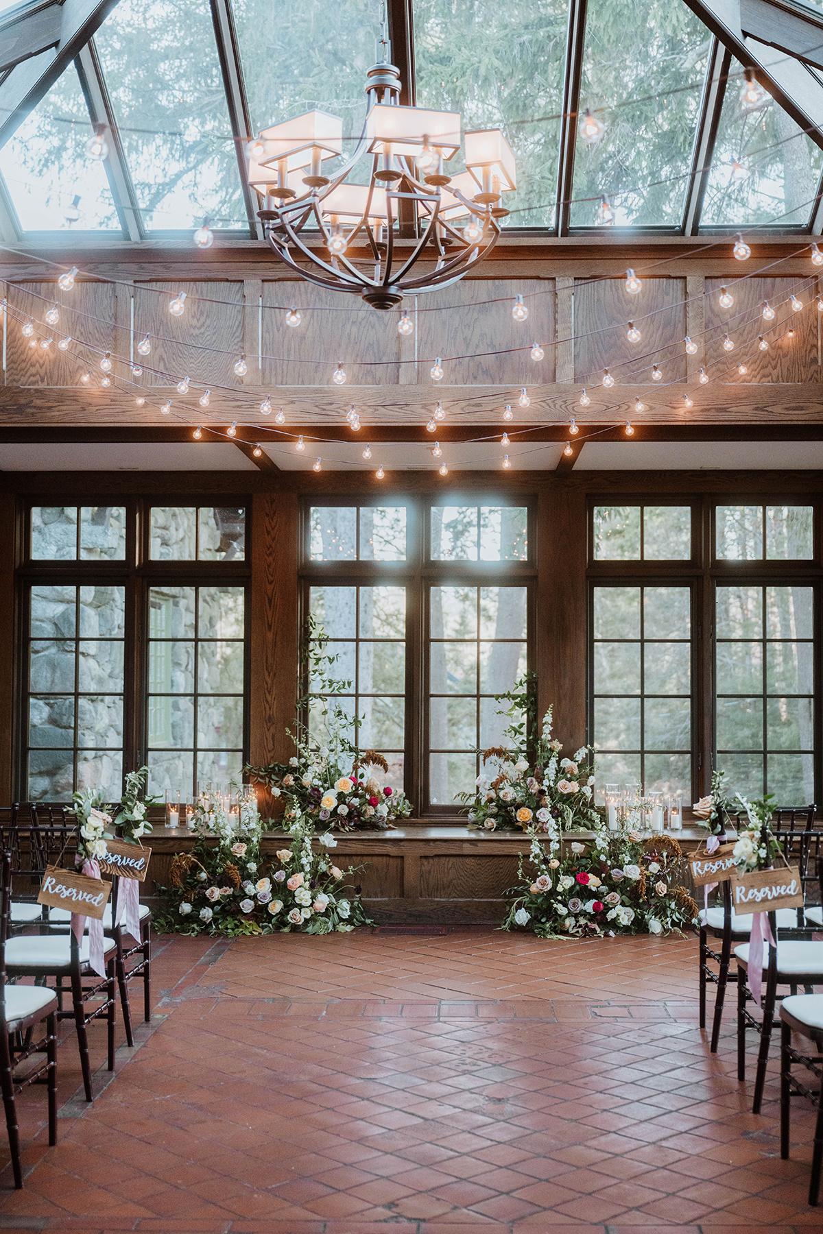Elegant indoor wedding venue with floral arrangements and string lights.