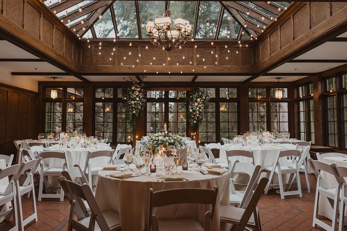 Elegant wedding venue with round tables and floral centerpieces.