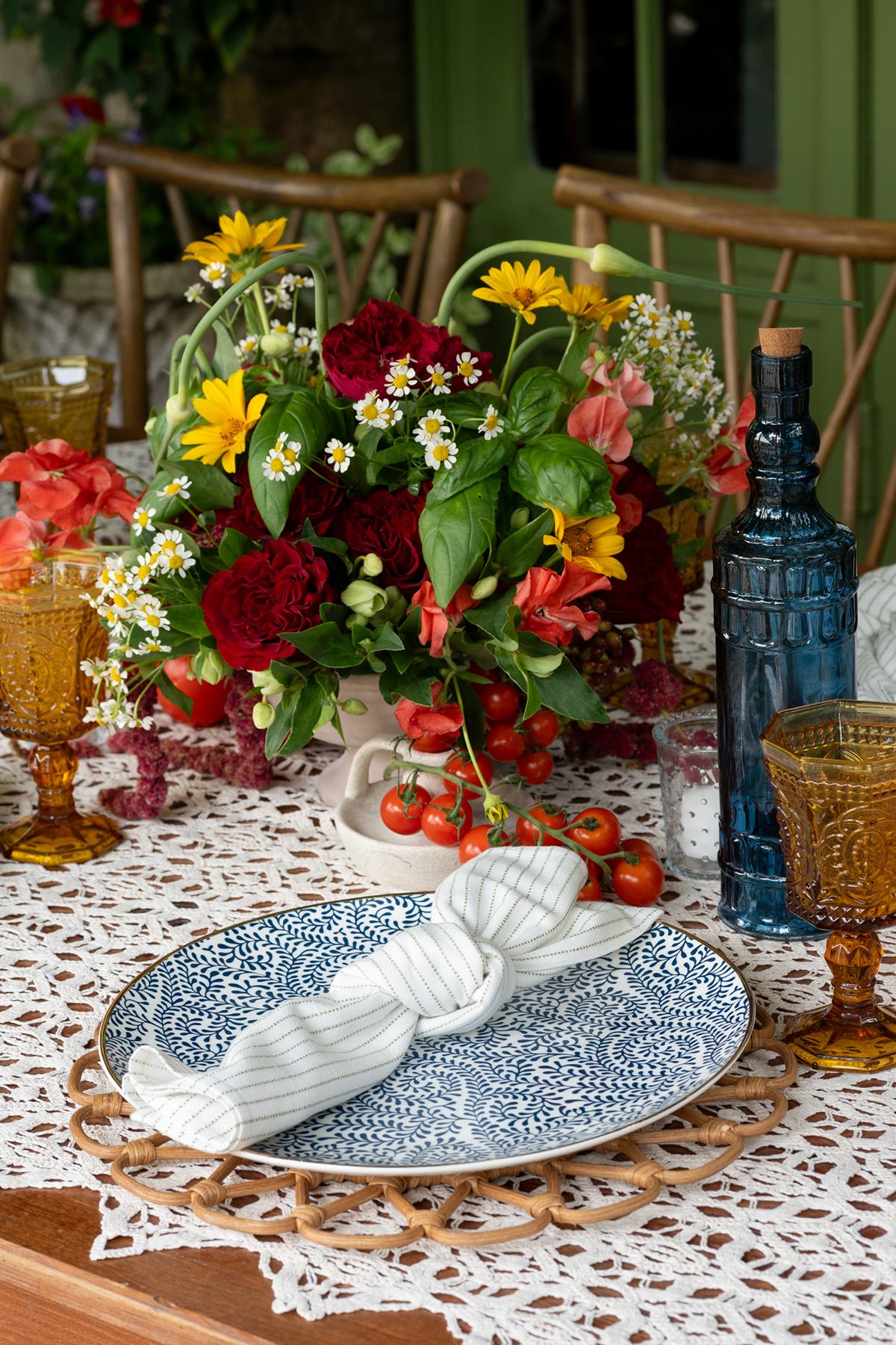 Elegant table setting with a floral centerpiece and patterned blue plate.
