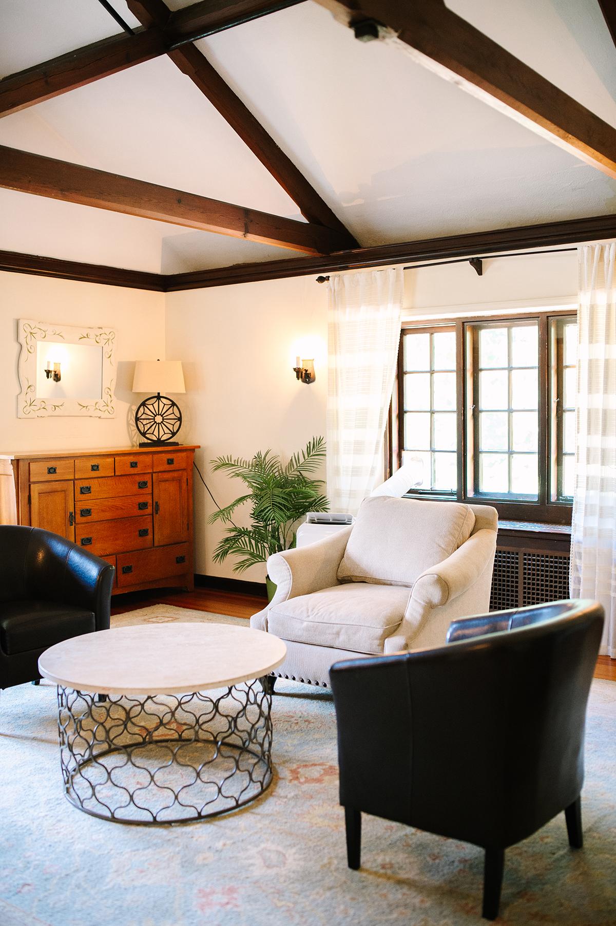 Cozy living room with armchairs, round table, and large window.