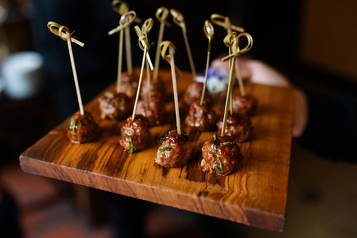 Skewered meatballs on a wooden board.