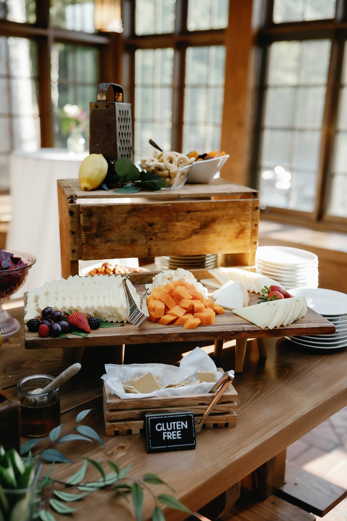 Cheese and fruit platter in sunlit room with wooden decor.