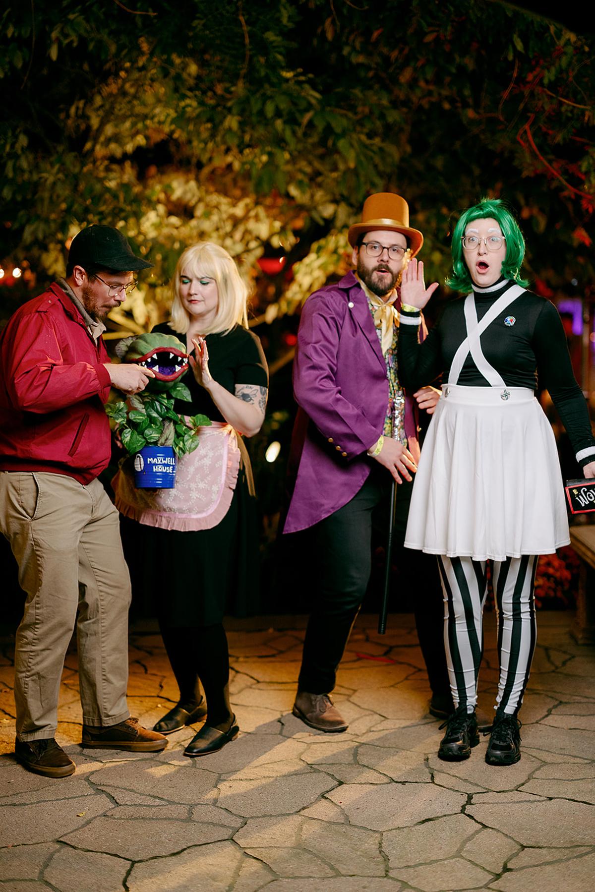 Four people in colorful costumes, posing outdoors at night.
