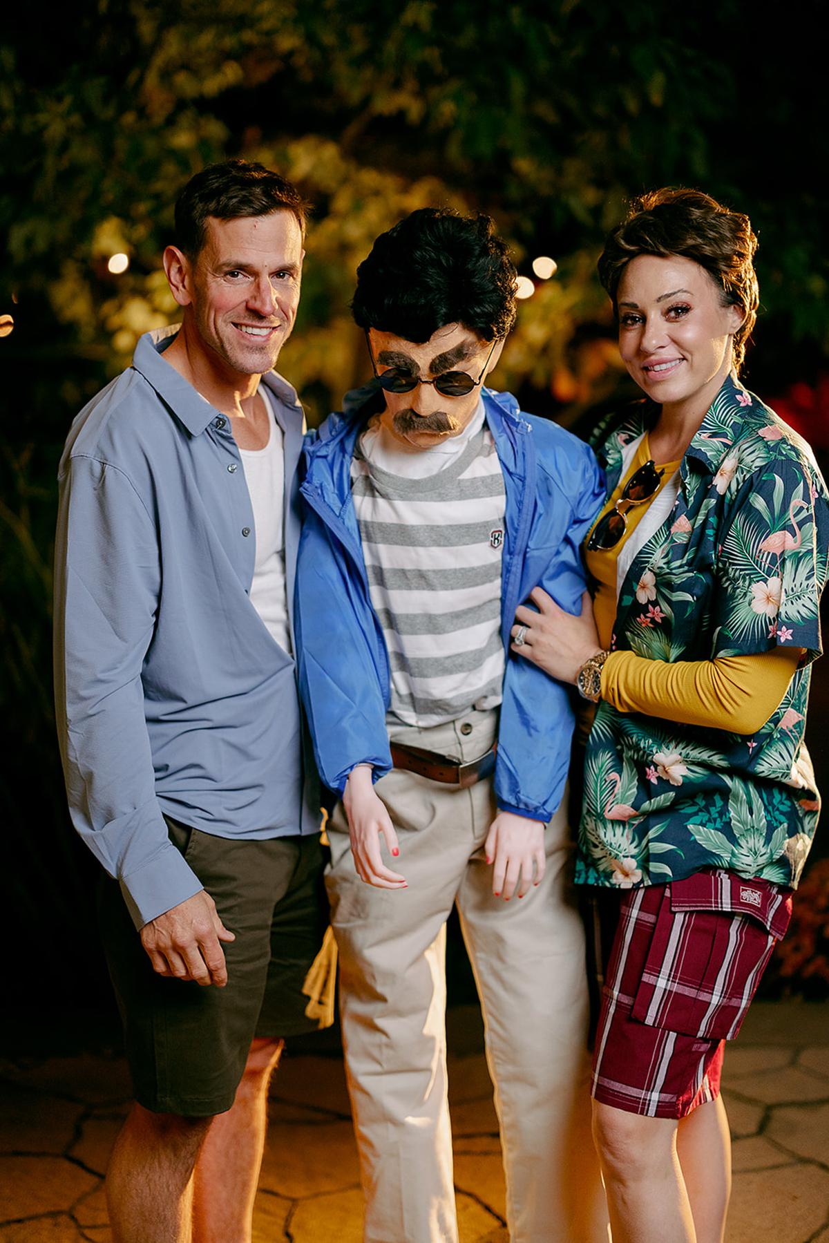 Three people in casual outfits, posing outdoors, smiling warmly.