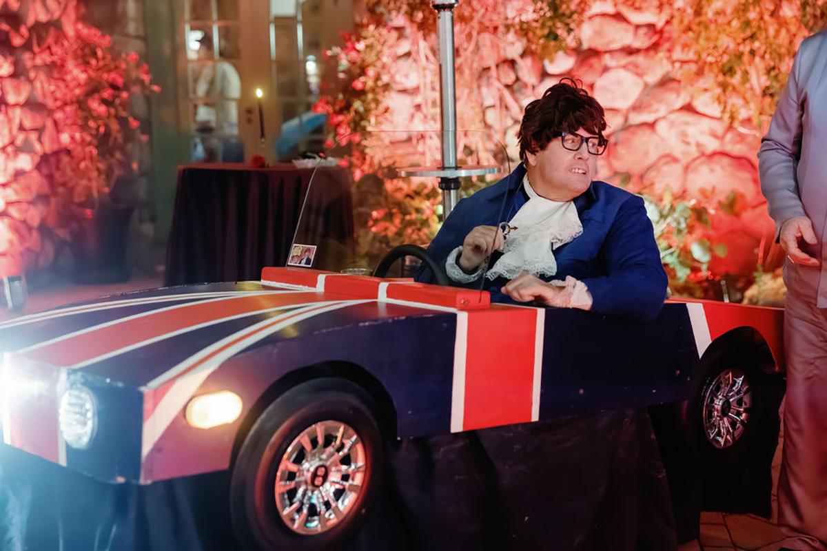 Person in a costume car with a Union Jack design in a fun, colorful setting.
