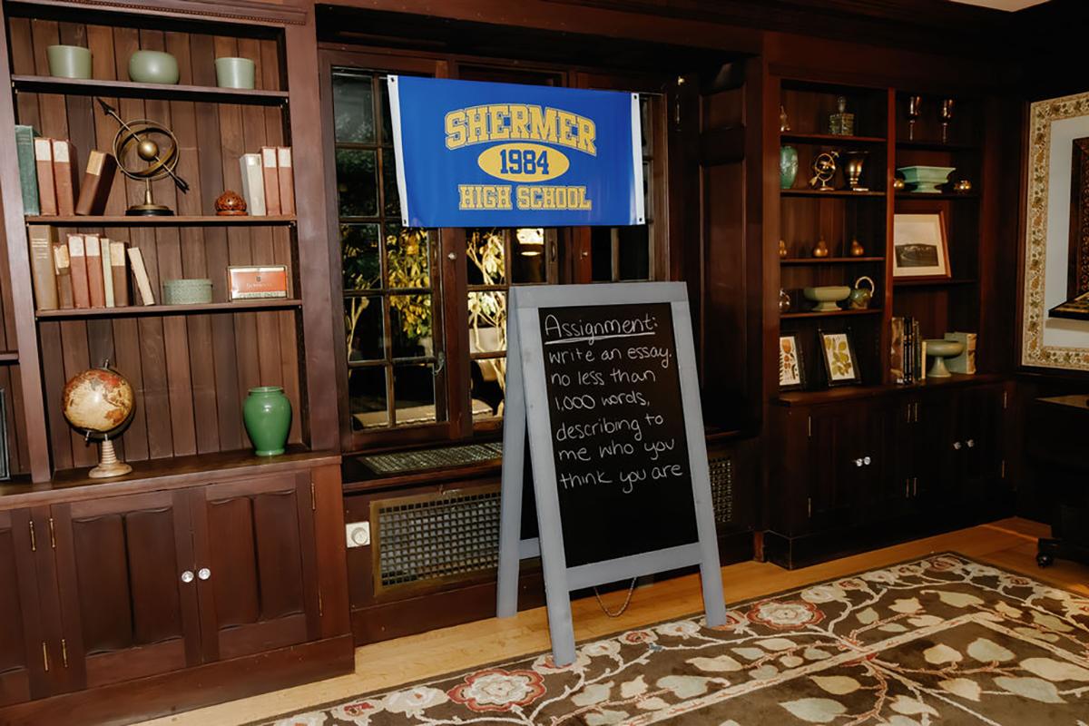 Shelves with books and decor, Shermer High School banner, chalkboard sign.