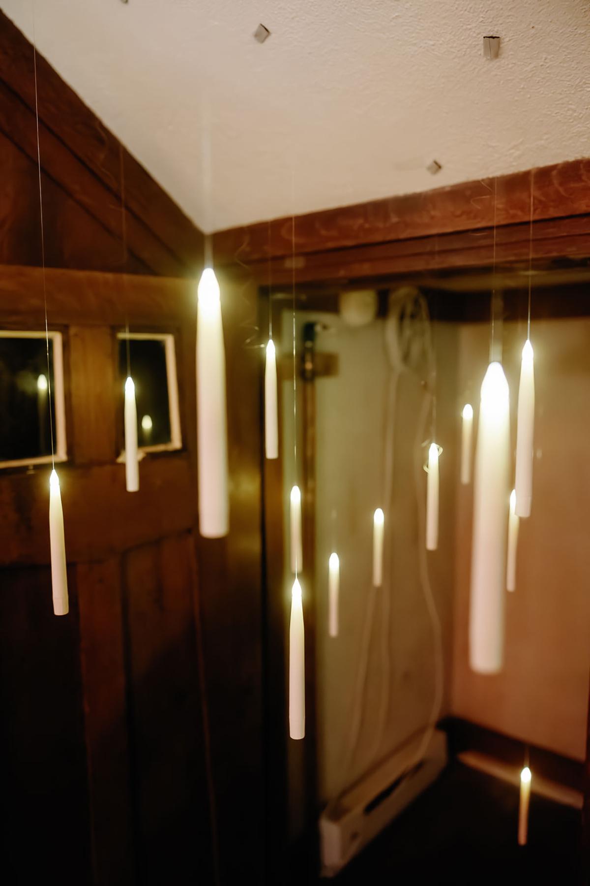 Floating candles suspended in a dimly lit room.