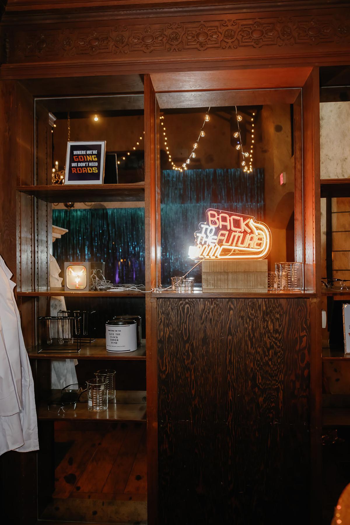 Dimly lit bar interior with neon sign and string lights.