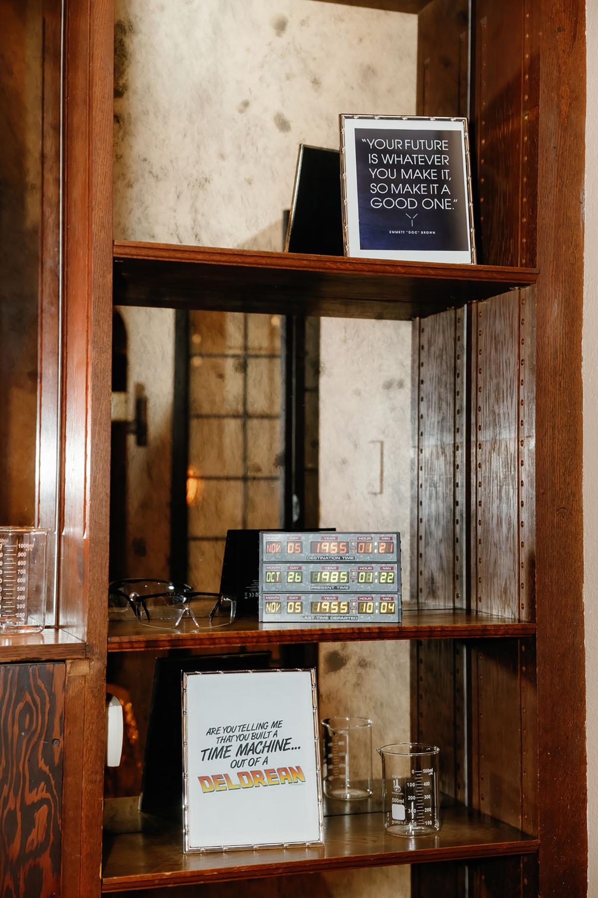 Rustic wooden shelf with framed quotes and glassware.