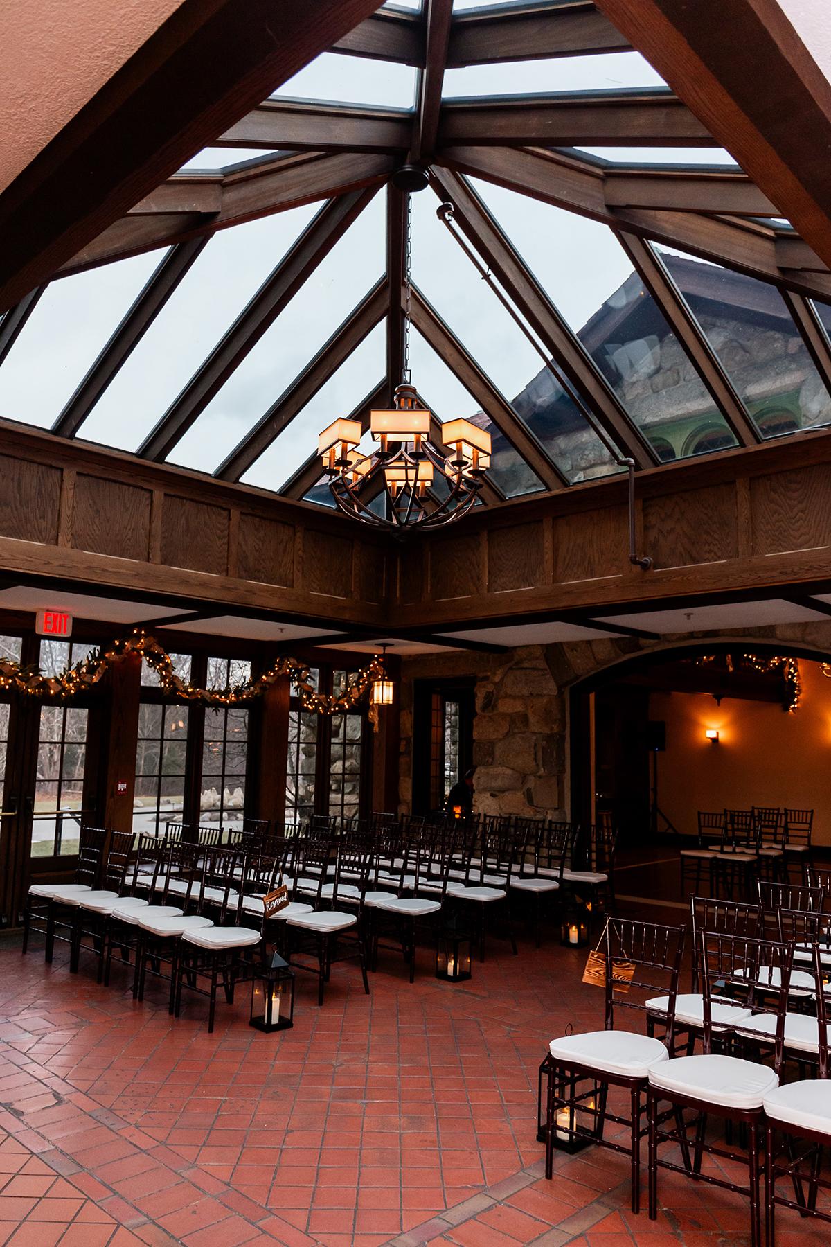 Indoor wedding venue with wooden beams and large glass windows.