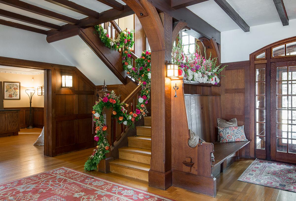 Decorated wooden staircase with floral garlands and soft lighting.