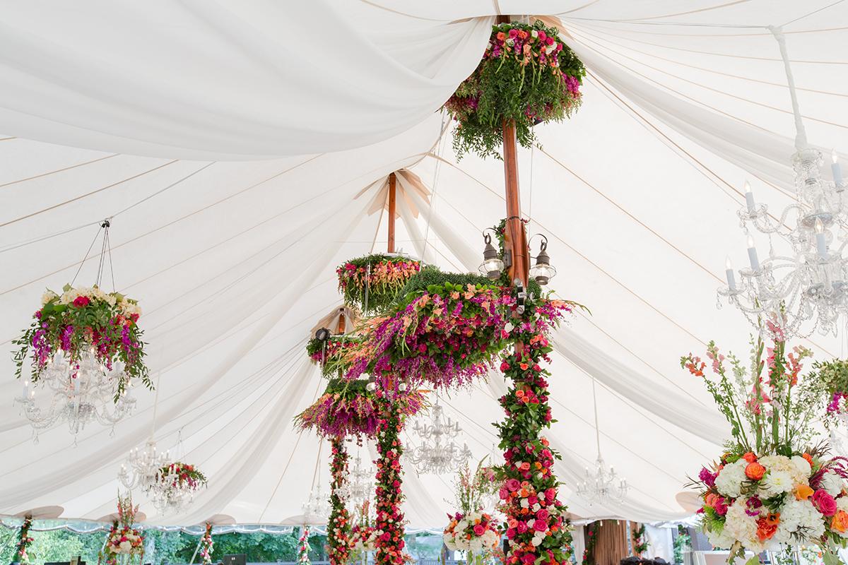 Elegant tent ceiling adorned with vibrant floral arrangements.