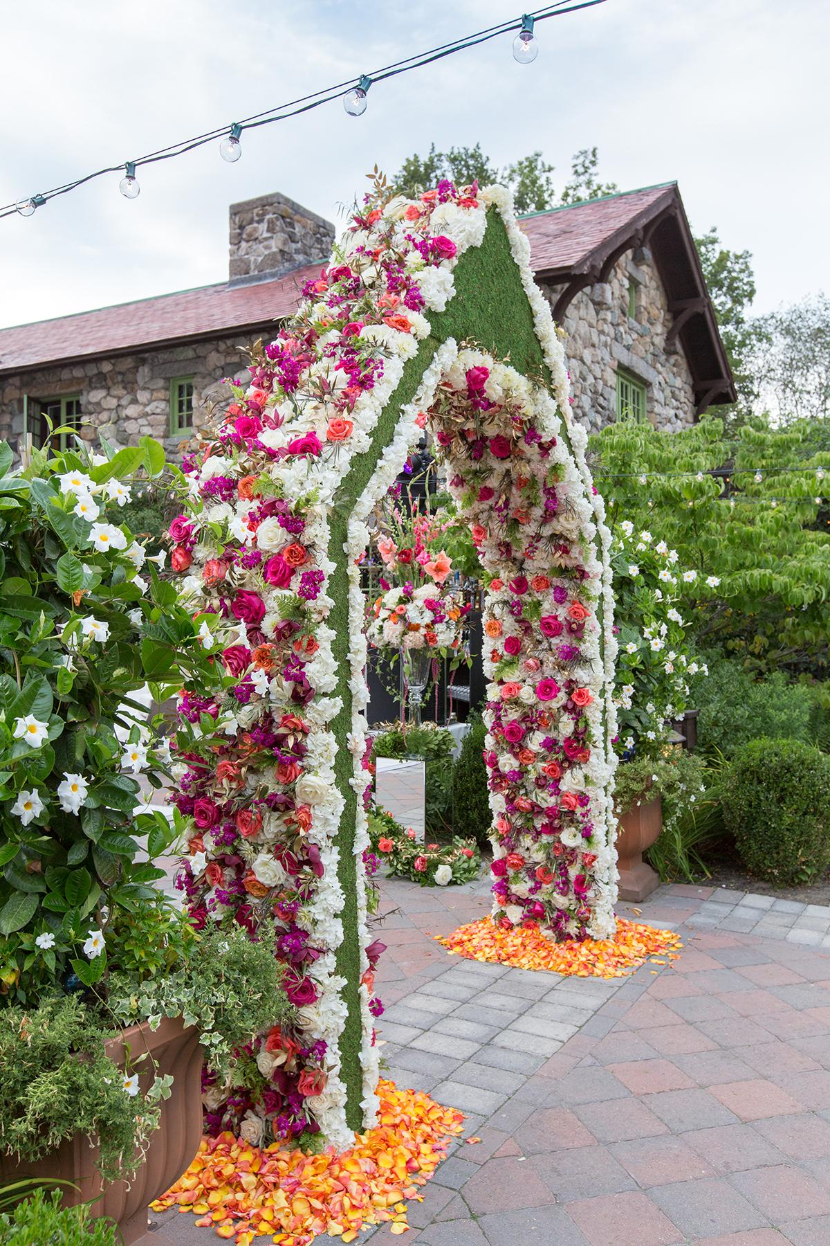Floral arch with colorful flowers on a garden path.