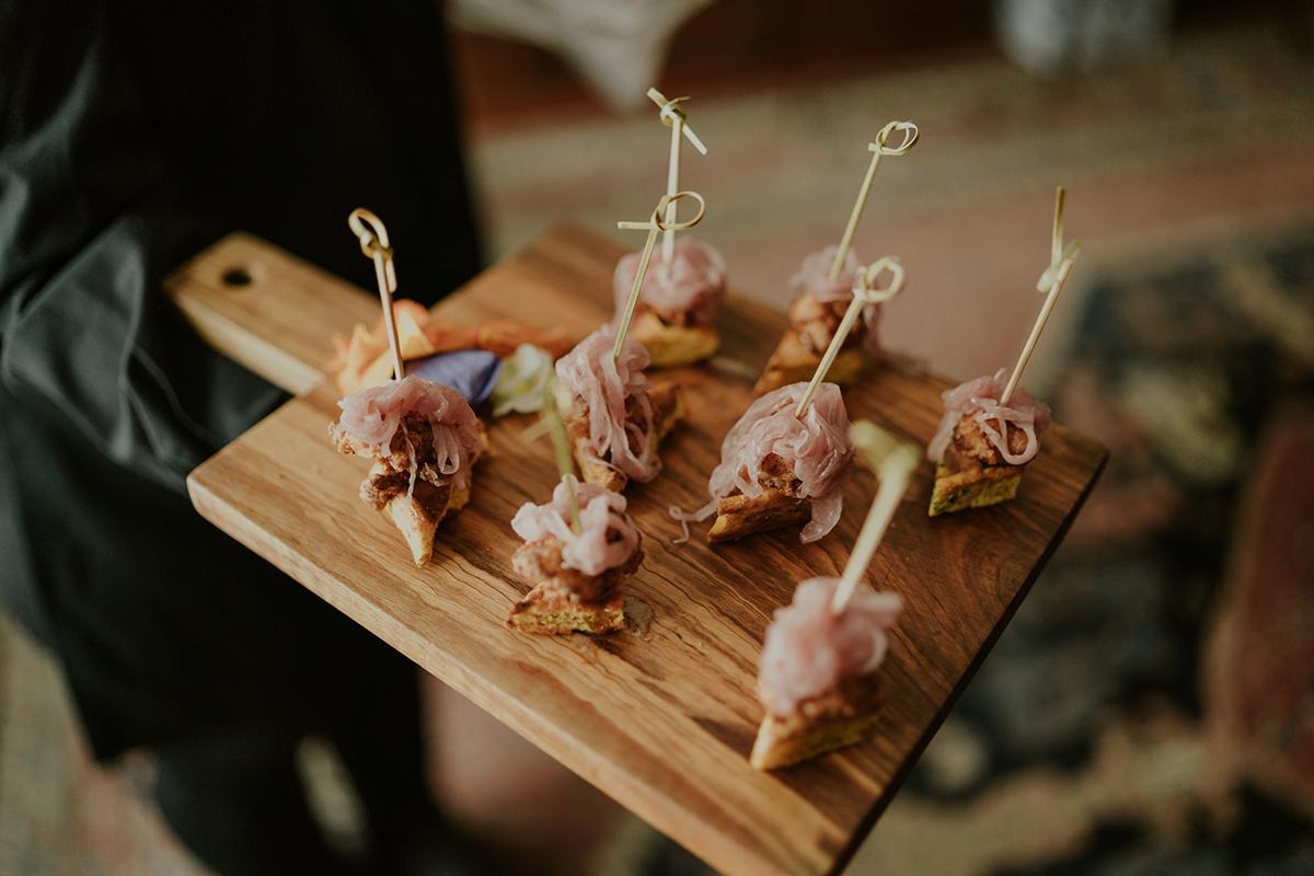 Appetizers with skewers on a wooden board.