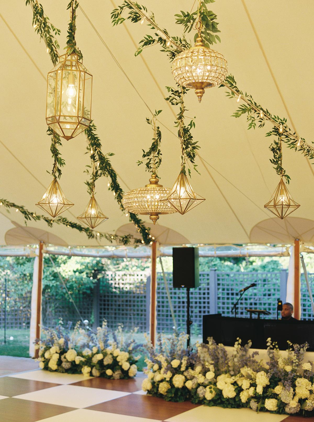 Elegant wedding reception with hanging lights and floral arrangements.