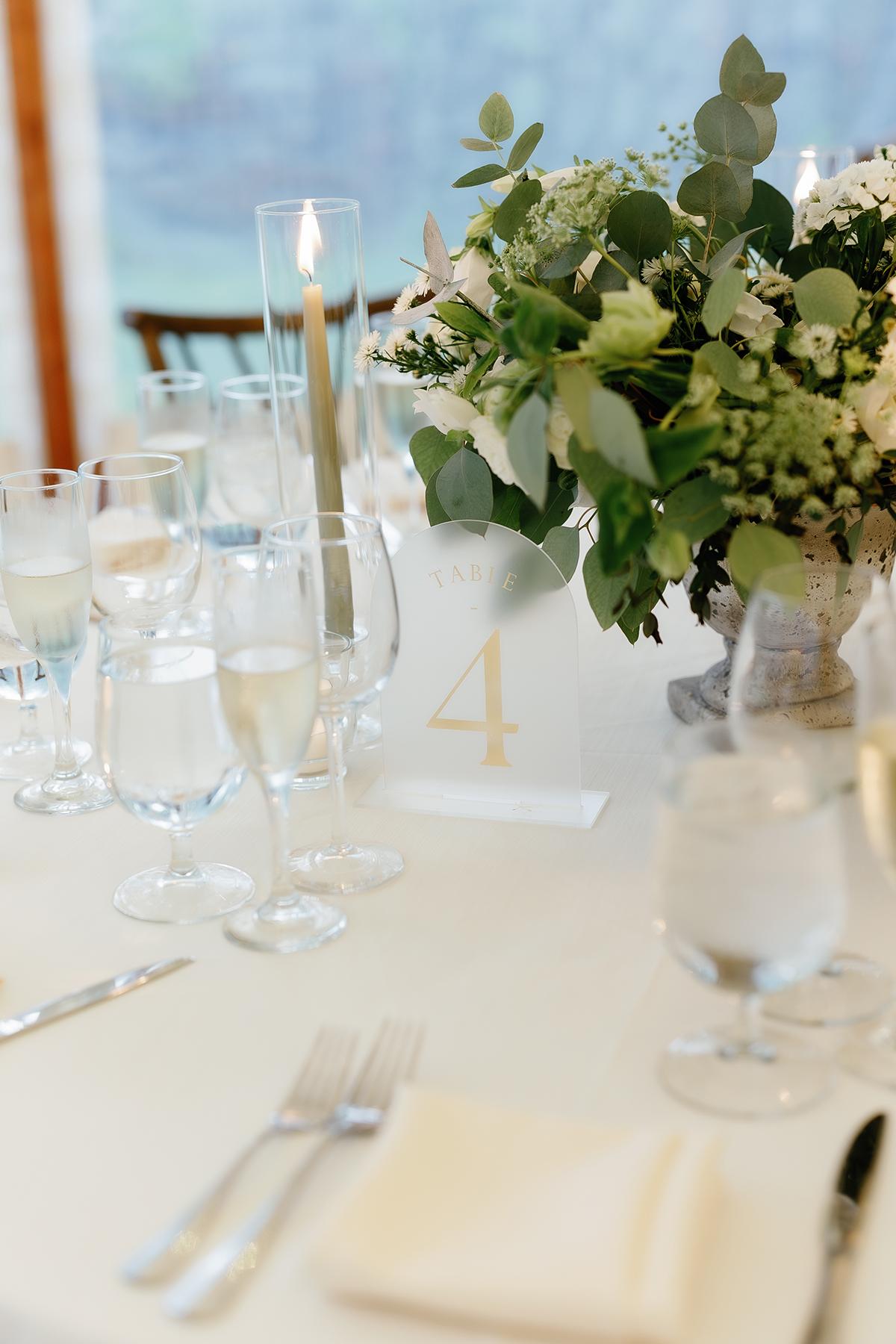 Elegant table setting with flowers, wine glasses, and a tall candle.