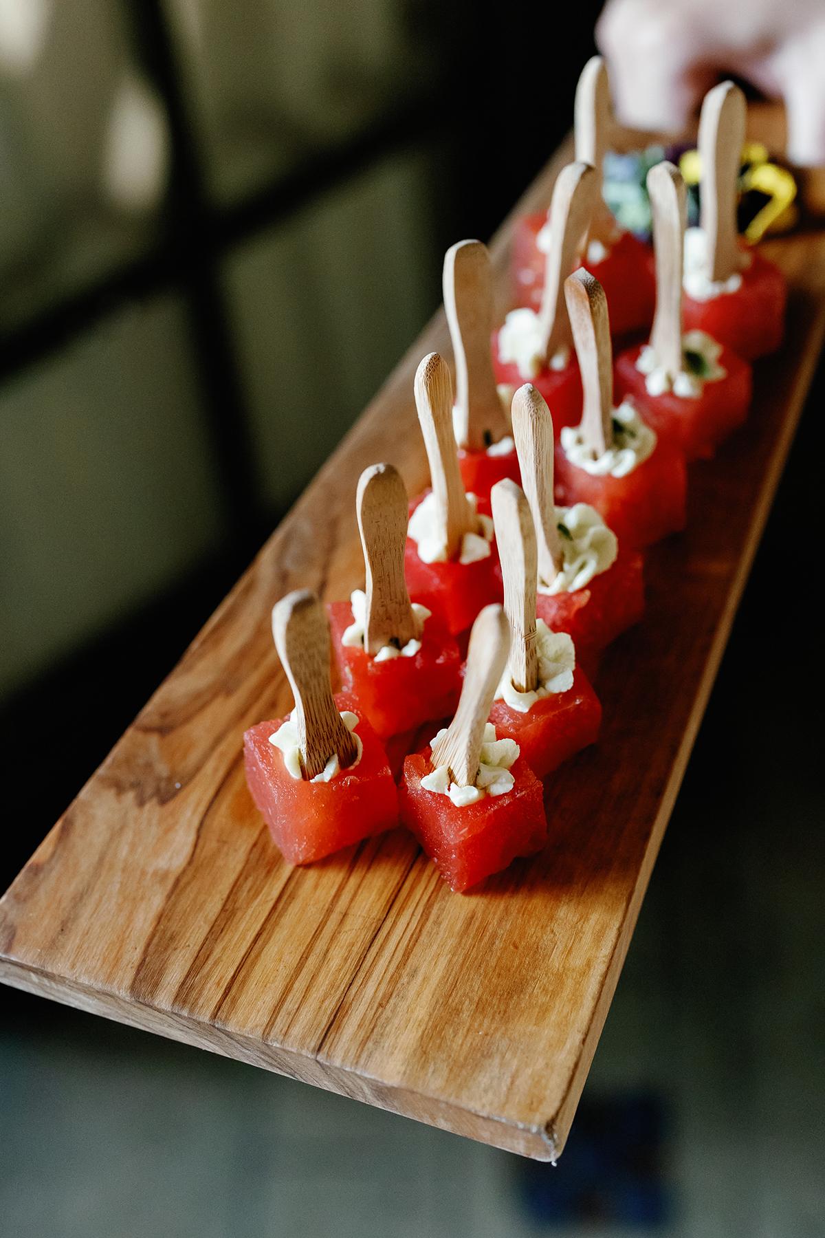 Watermelon, feta, and mint appetizers on a wooden board.