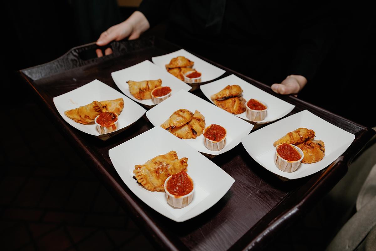 Tray with six plates of appetizers and dip.