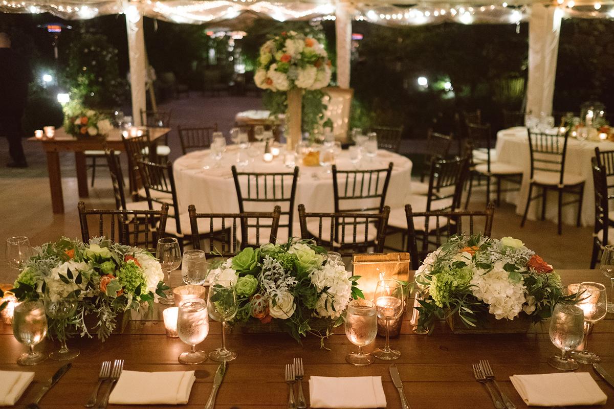 Elegant wedding reception setup with floral centerpieces and twinkling lights.