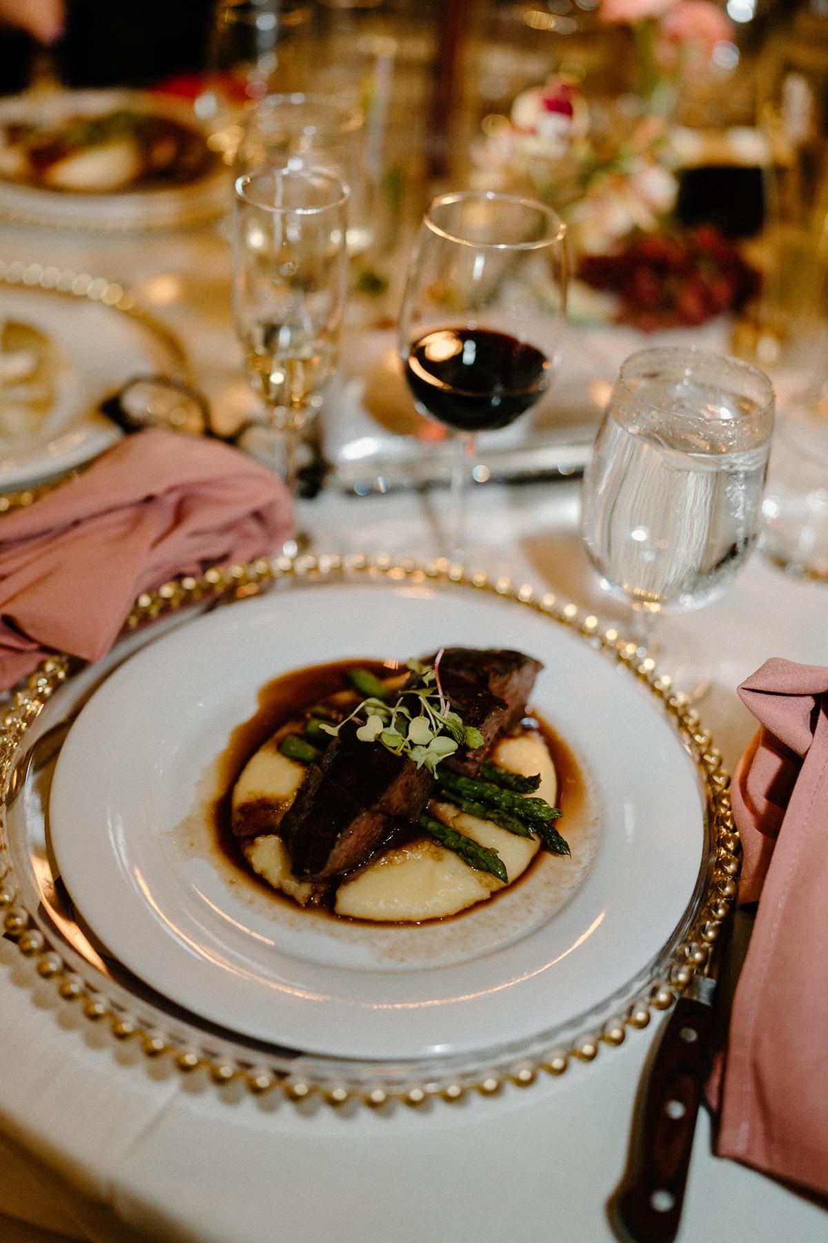 Elegant table setting with plated beef and asparagus.