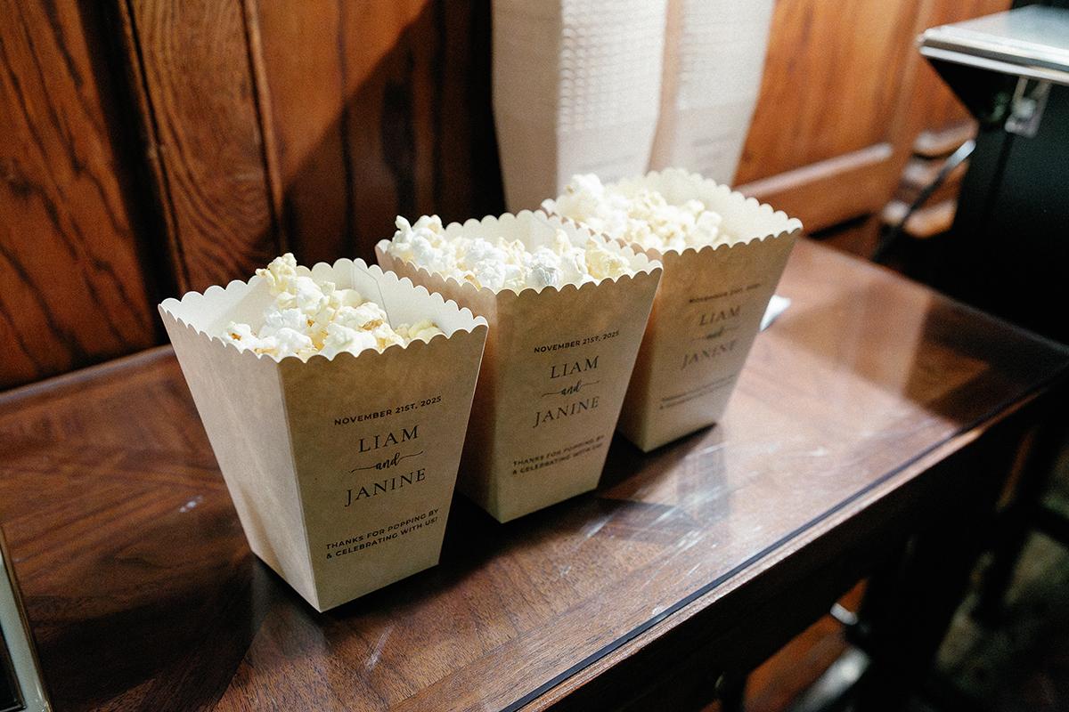 Three popcorn bags on a wooden table.