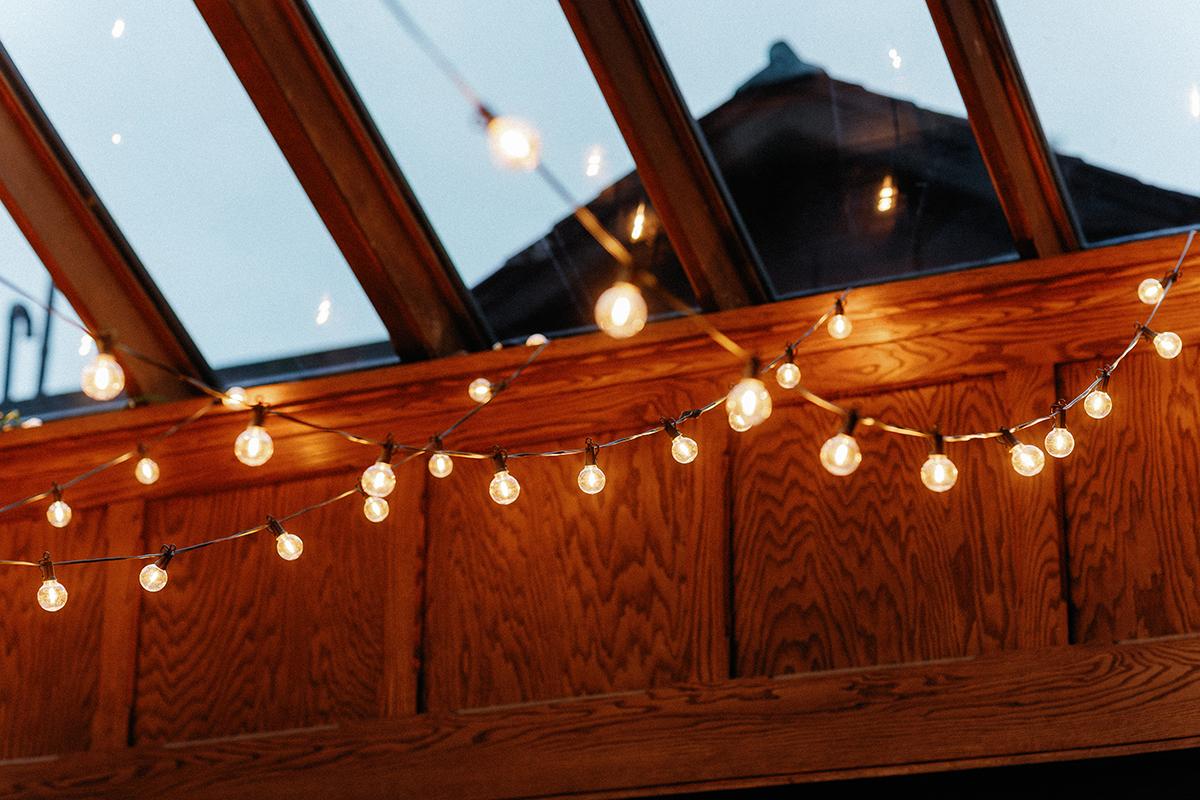 String lights hanging under a skylight ceiling at twilight.