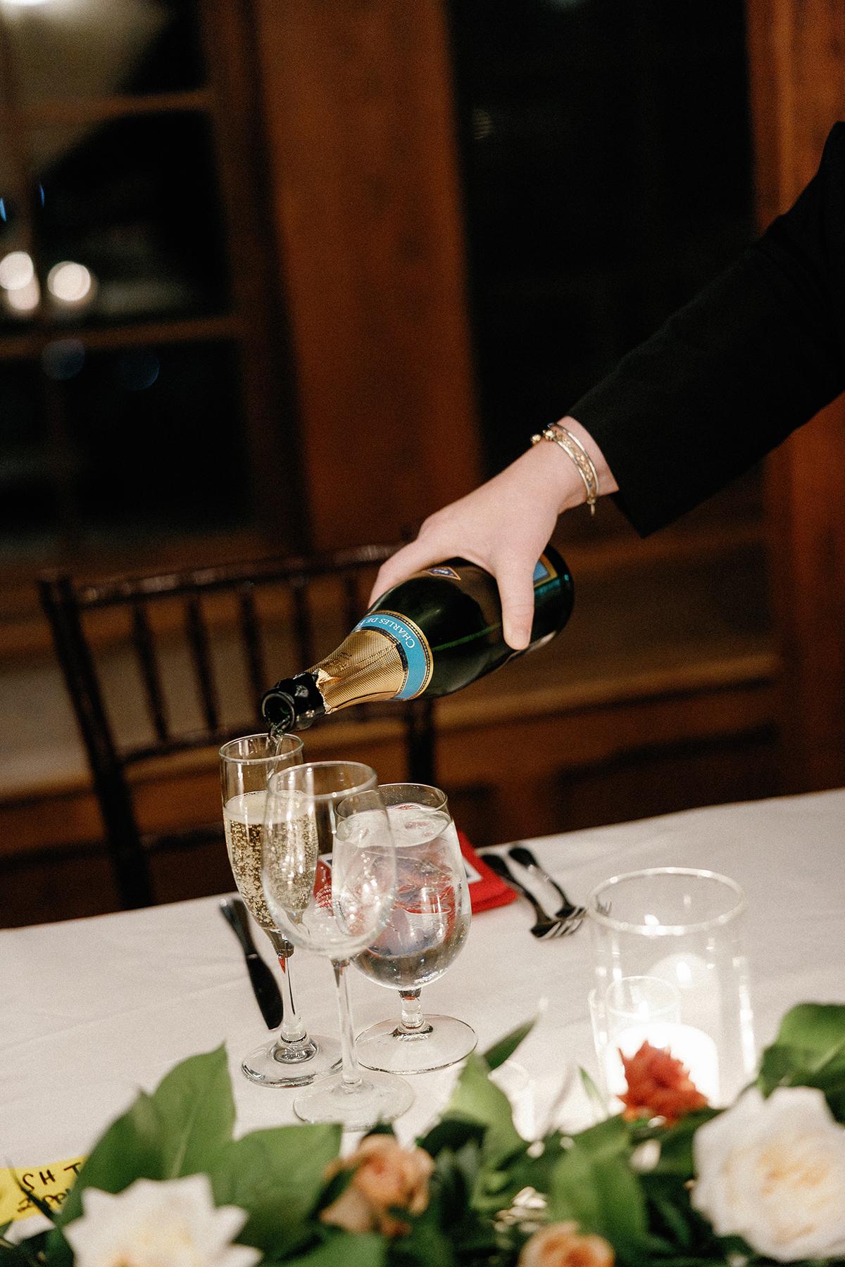 Pouring champagne into a glass at an elegant table setting.