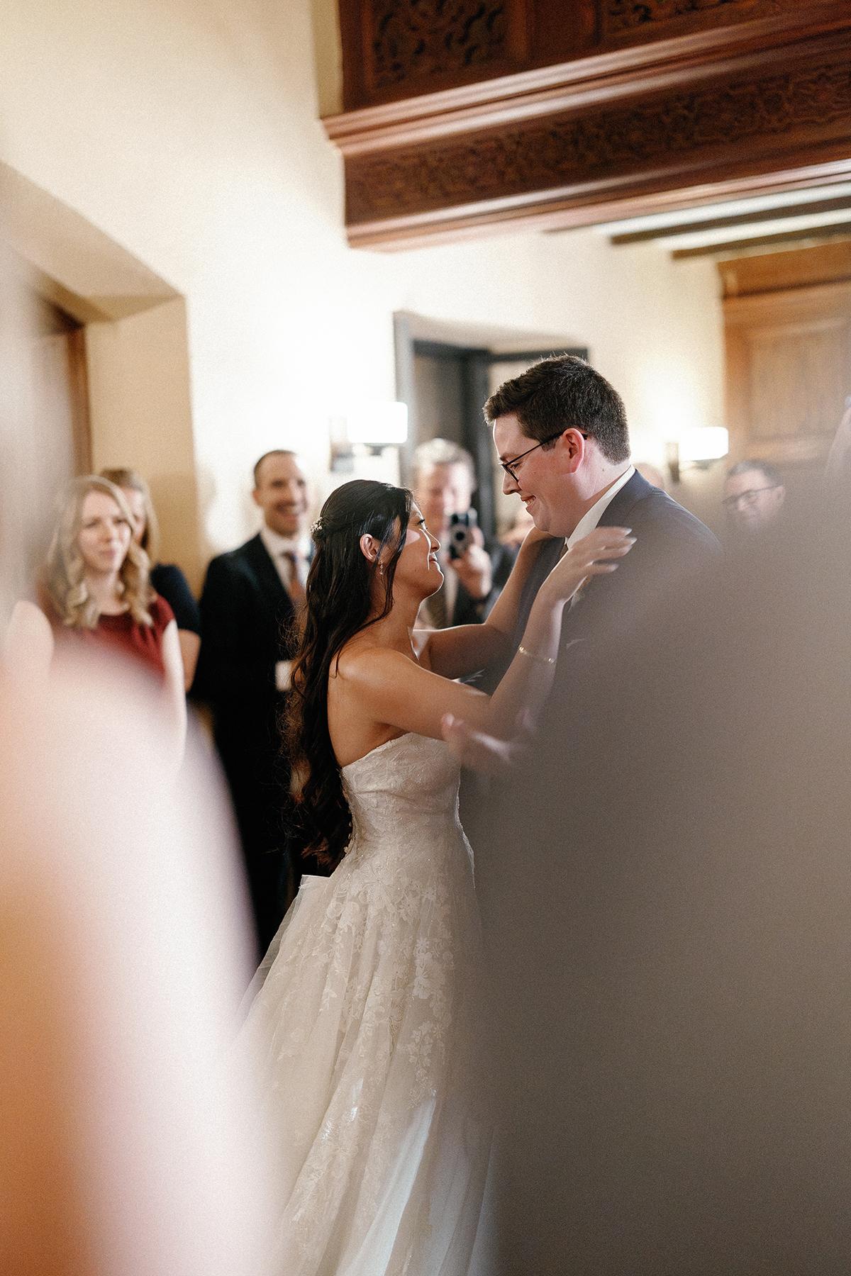 Couple dancing in elegant attire at a wedding reception.