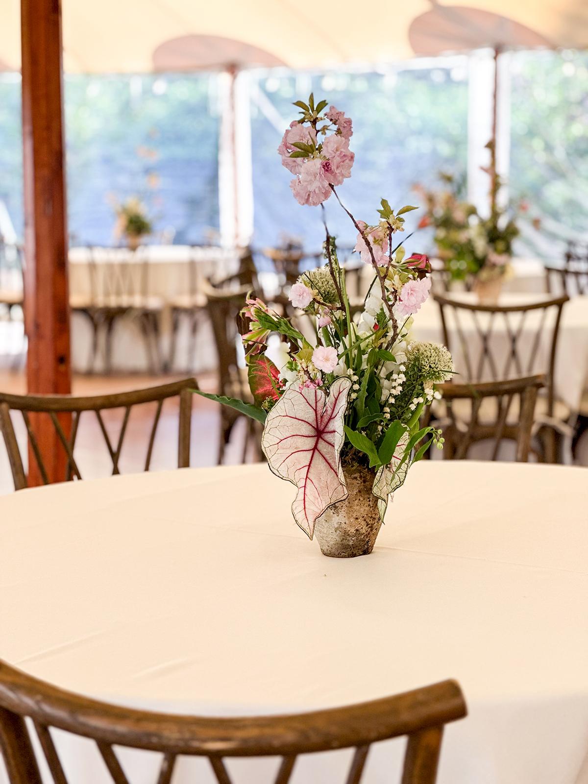 Flower arrangement on a round table in a bright, airy room.