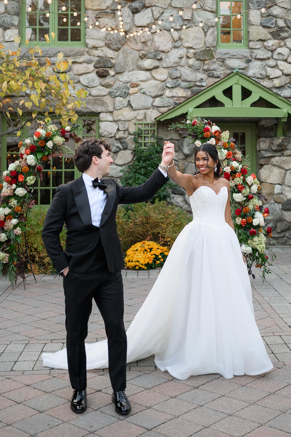 Couple in wedding attire smiling in a garden setting.