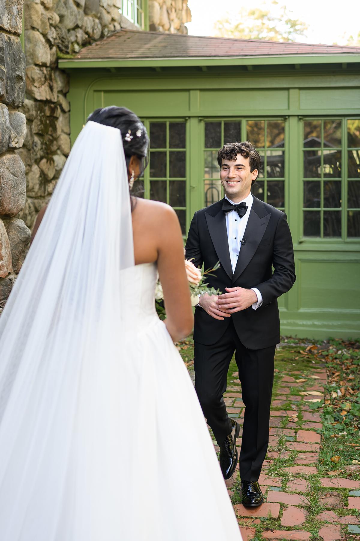 Bride and groom smiling in a garden setting.