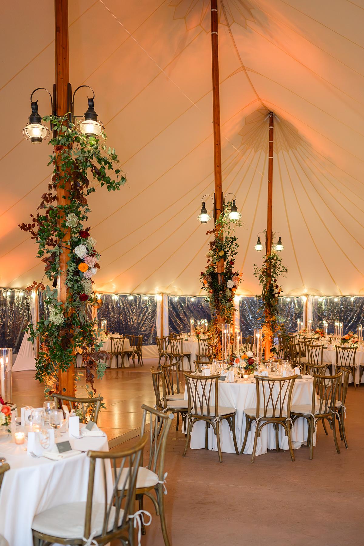 Elegant wedding reception with decorated tables and draped tent.