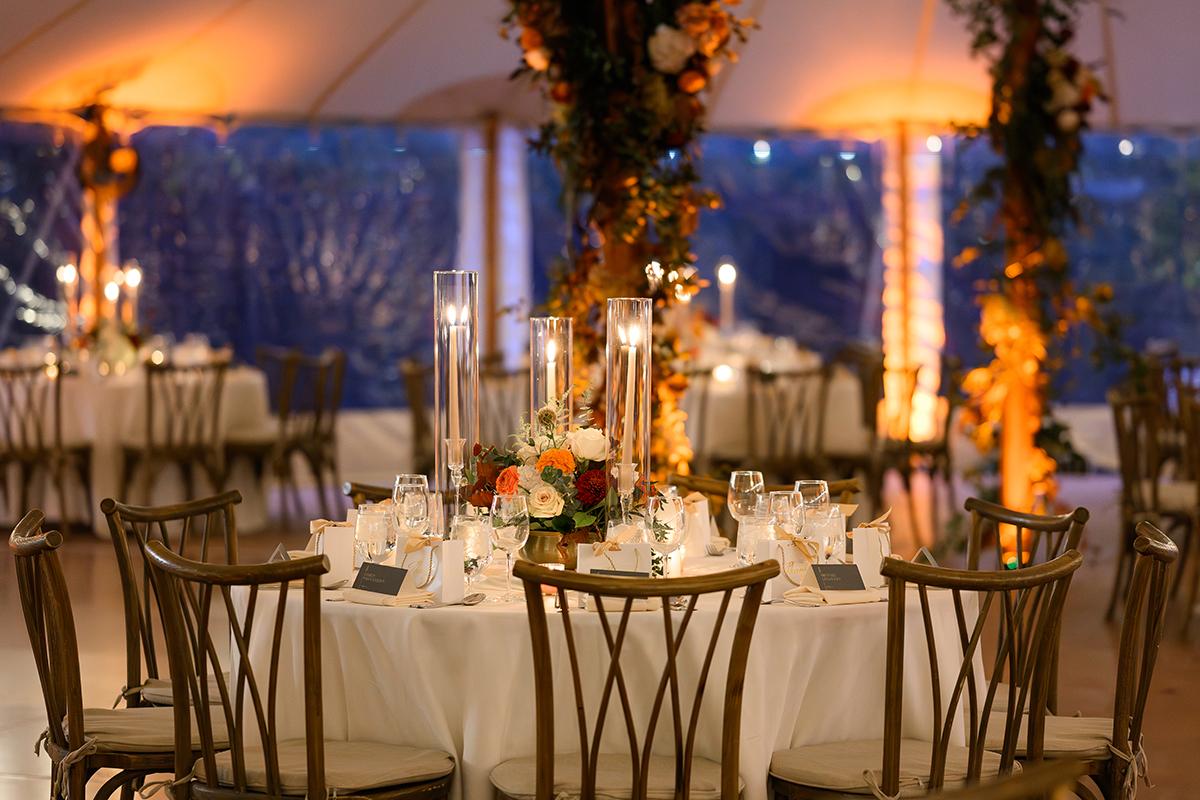 Elegant wedding reception setup with round tables, floral centerpieces, and ambient lighting.