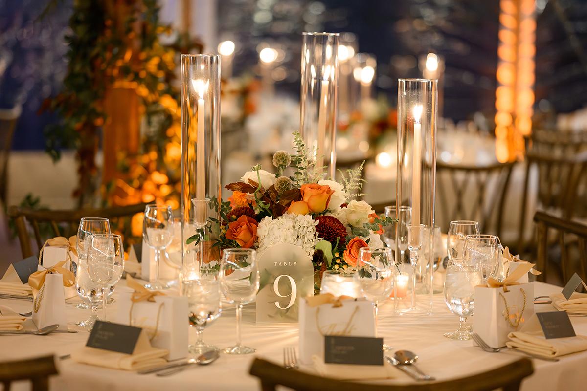 Elegant wedding table with floral centerpiece and glowing candles.