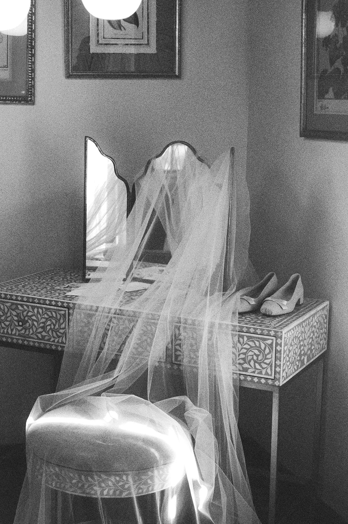 Vanity table with a mirror, a veil, and shoes in black and white.