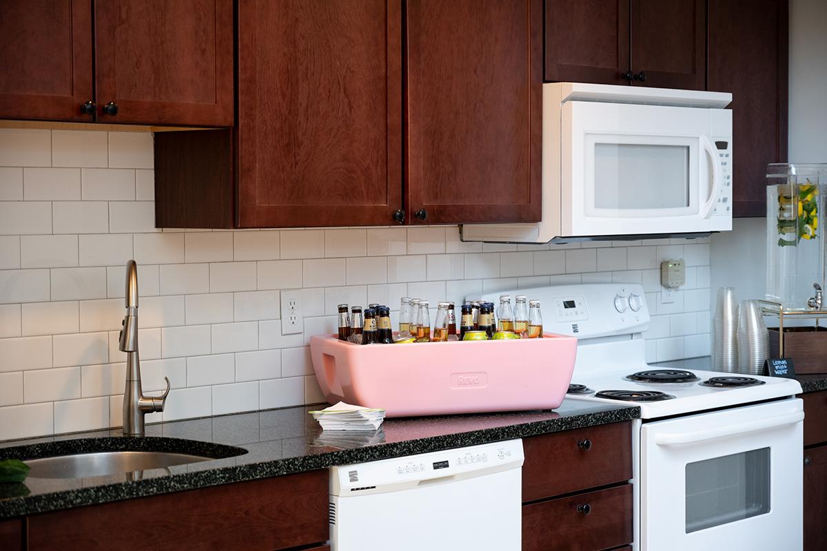 Kitchen with wooden cabinets, white appliances, and pink tray on countertop.